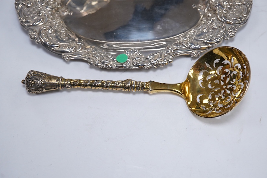 Two Victorian silver sugar bowls, a Victorian silver gilt sifter ladle and a repousse silver dish, 11.8oz. Condition - fair to good